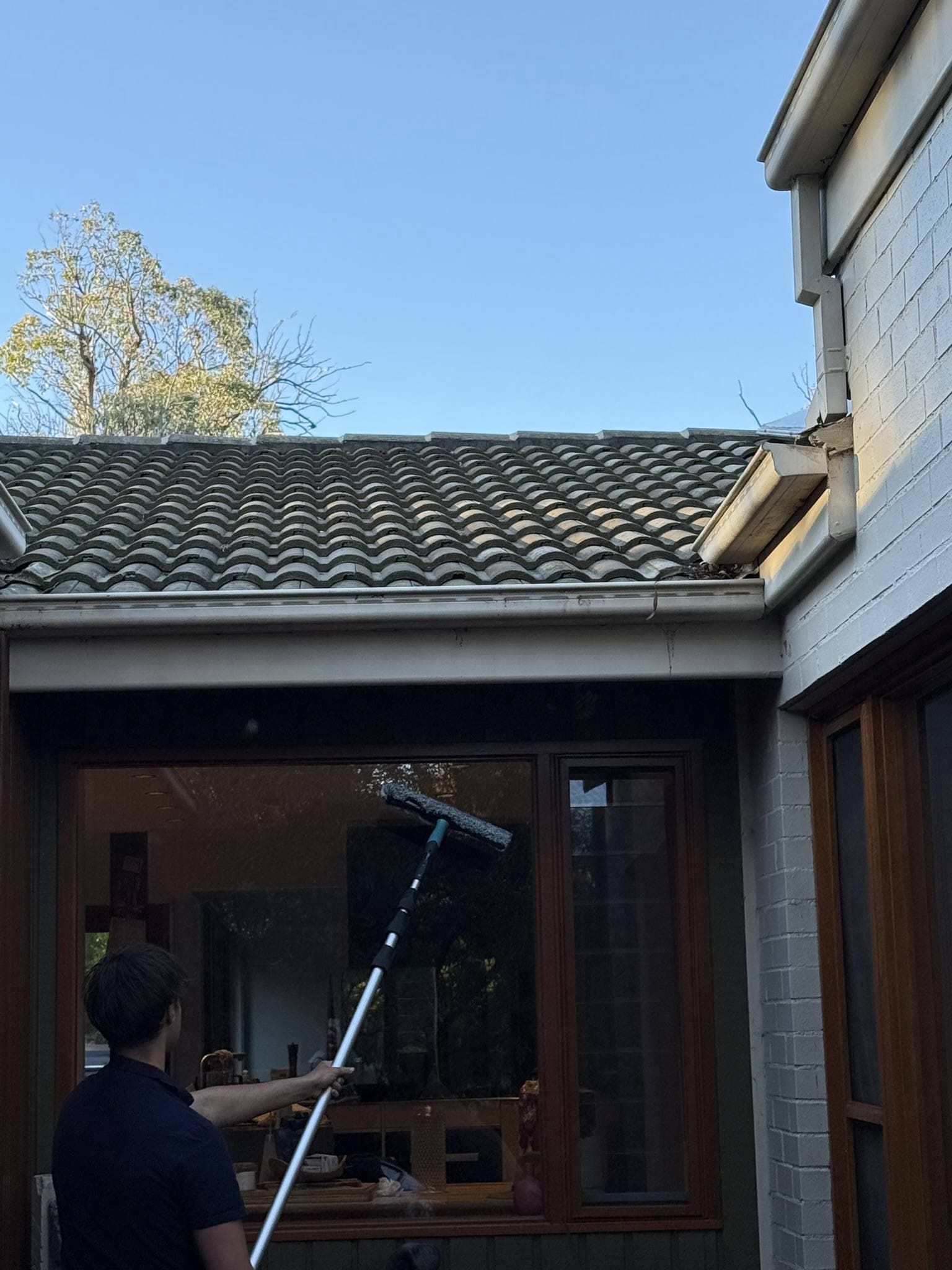 Glass & Blast team cleaning high windows with an extension pole